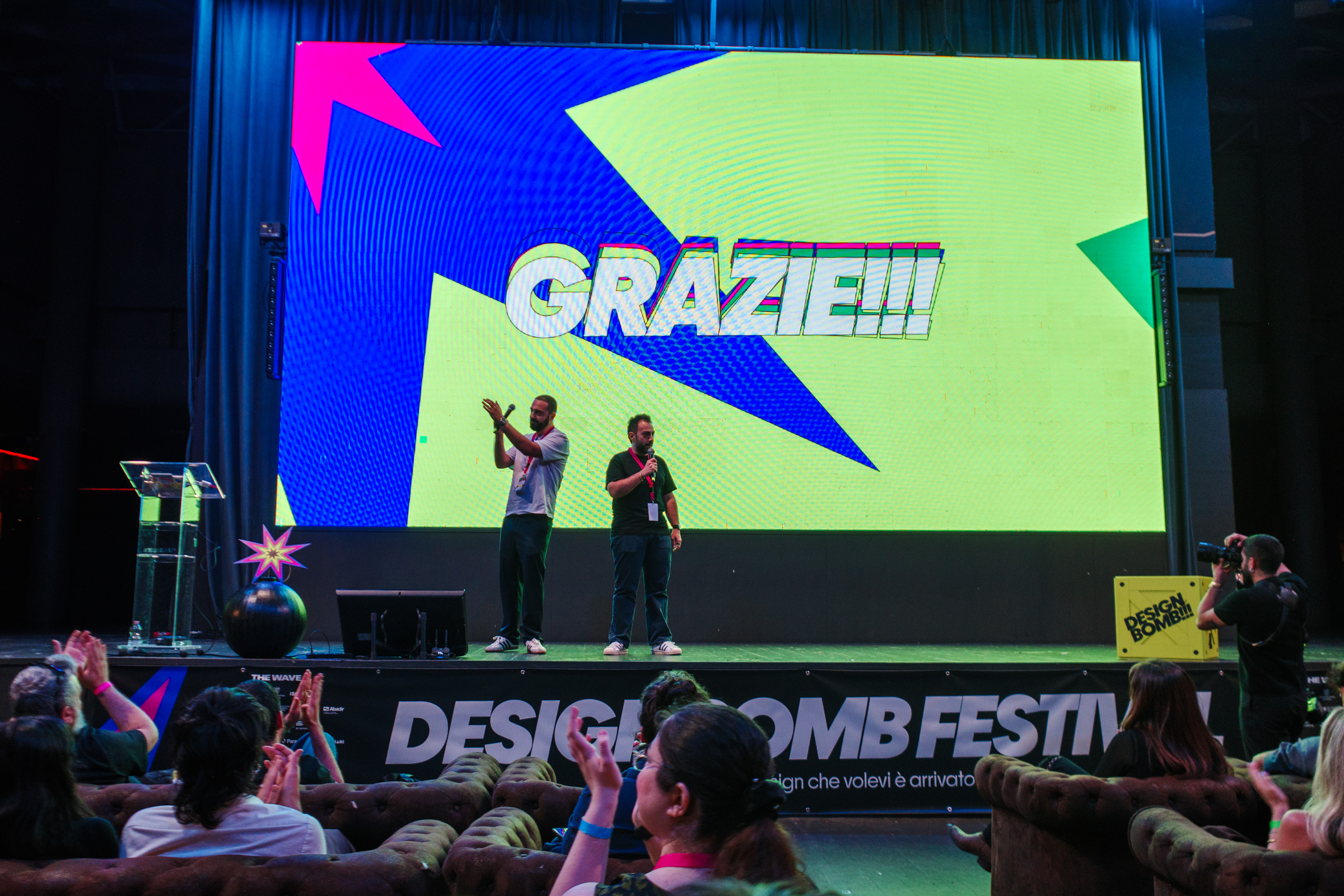 Il palco del Design Bomb Festival con la slide Grazie e il pubblico che applaude
